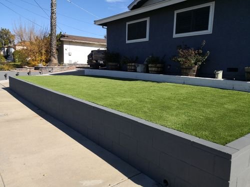 elevated artificial grass front yard to emphasize the paved driveway